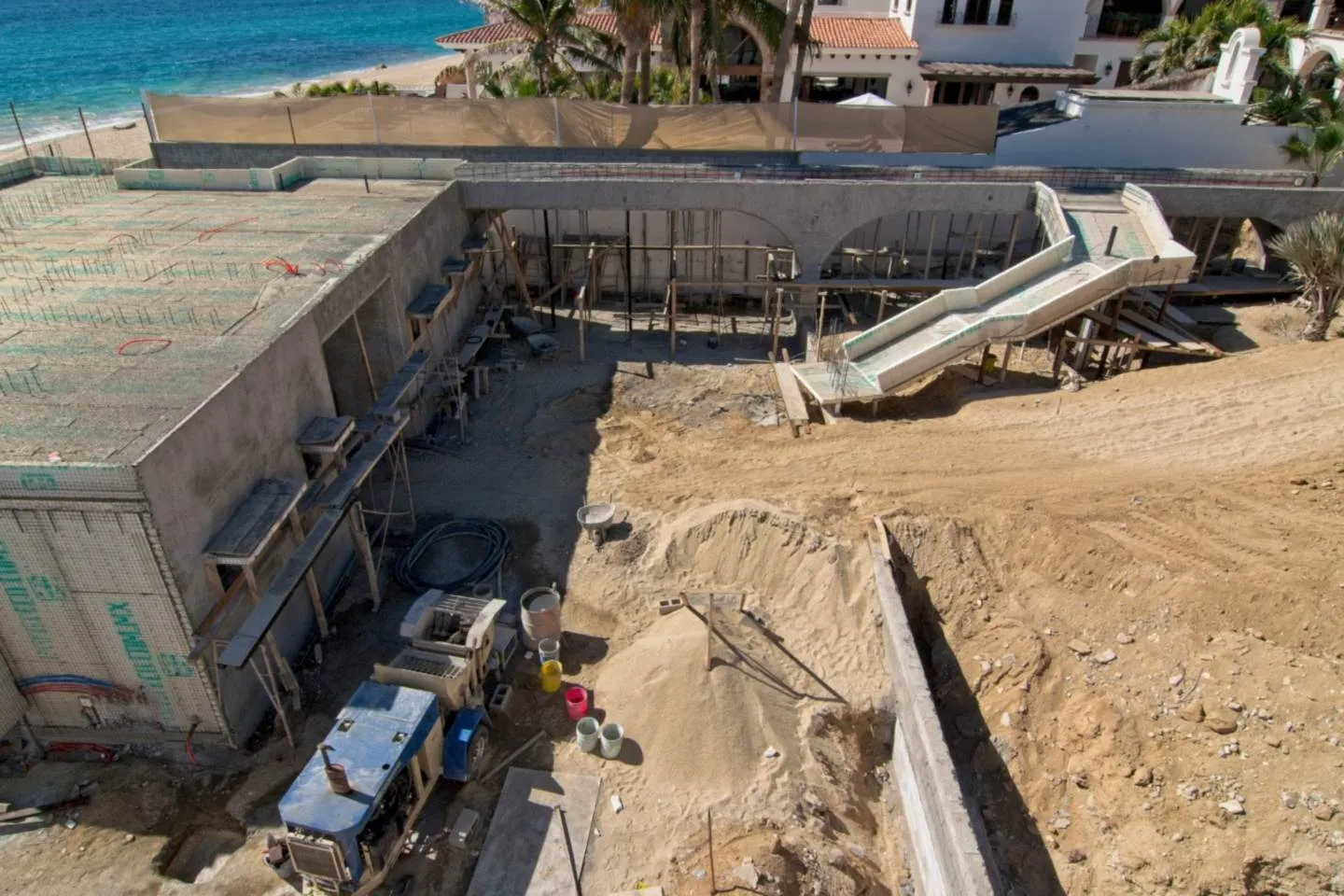 Vista aérea de la cimentación ICF y la escalinata en formación, con el mar de fondo, proyecto El Encanto