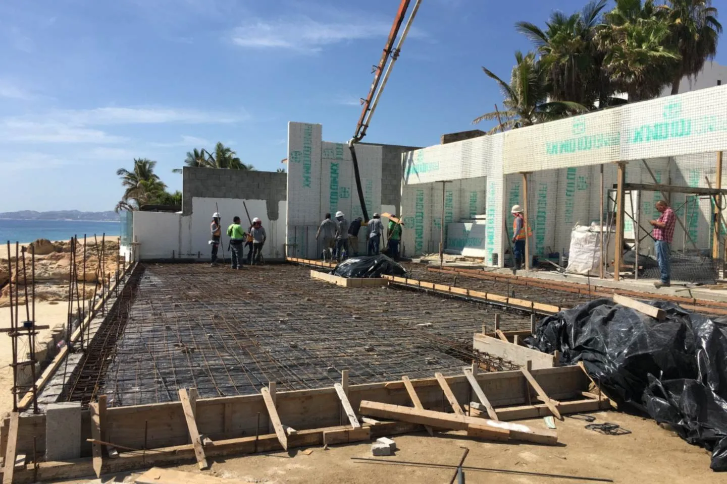 Armado de cimentación y cuadrilla trabajando, con el mar de fondo, proyecto El Encanto