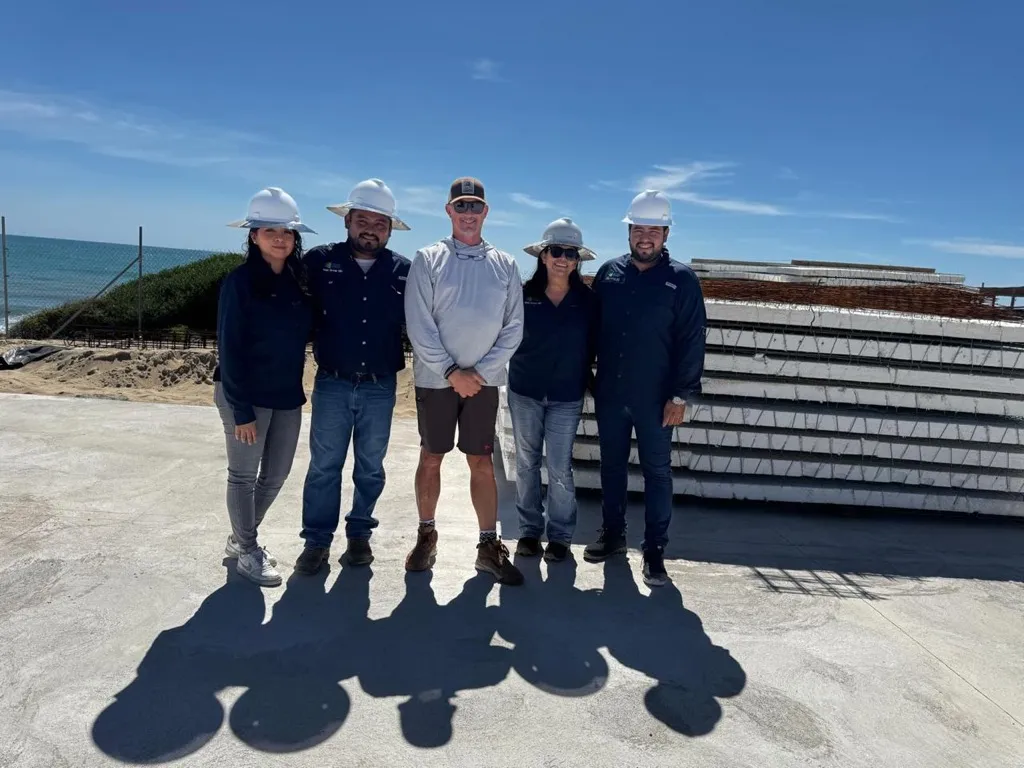 Equipo de SDM Group reunido en una obra frente al mar