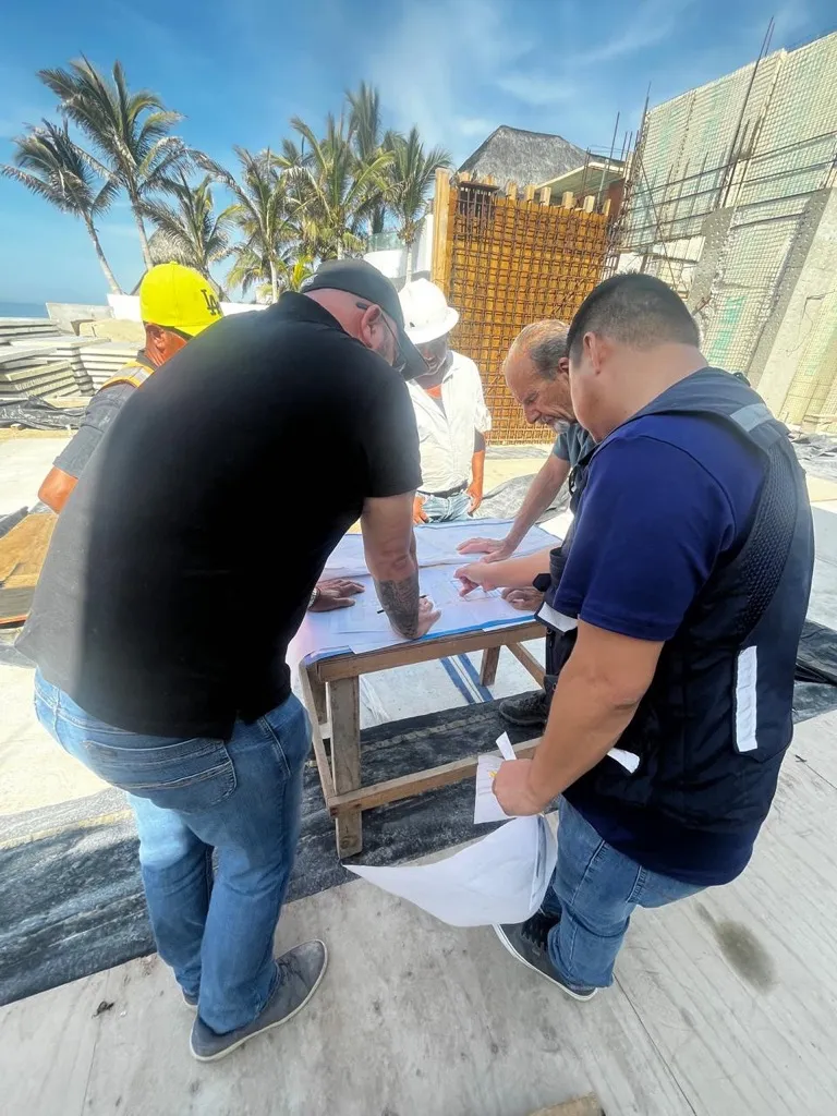 Equipo revisando planos durante una visita de obra