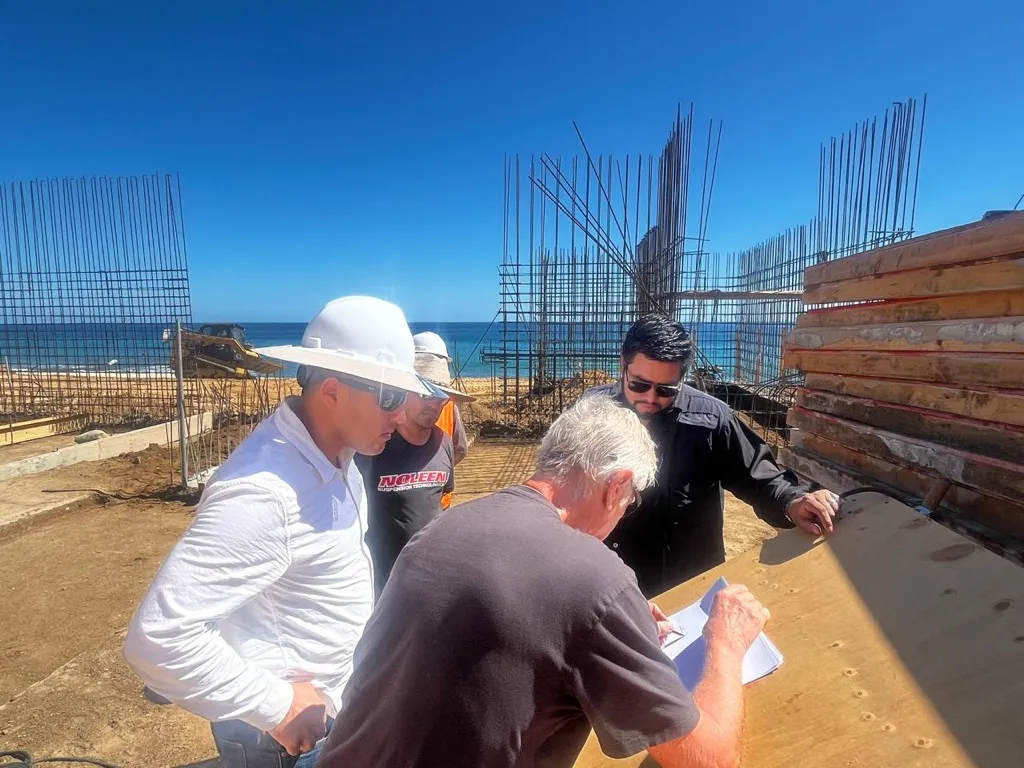 Revisión de planos junto a los muros estructurales en proceso